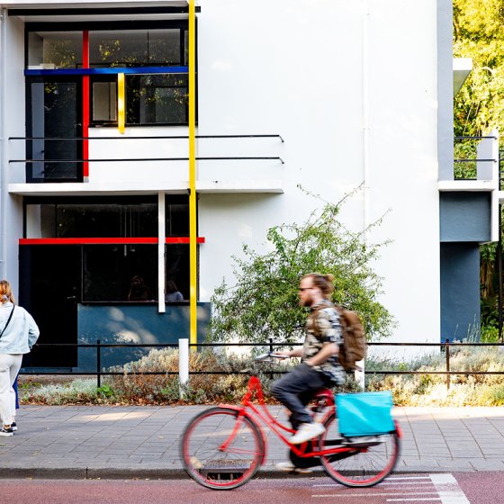 Radfahrer f&auml;hrt am Rietveld Schr&ouml;derhuis in Utrecht vorbei
