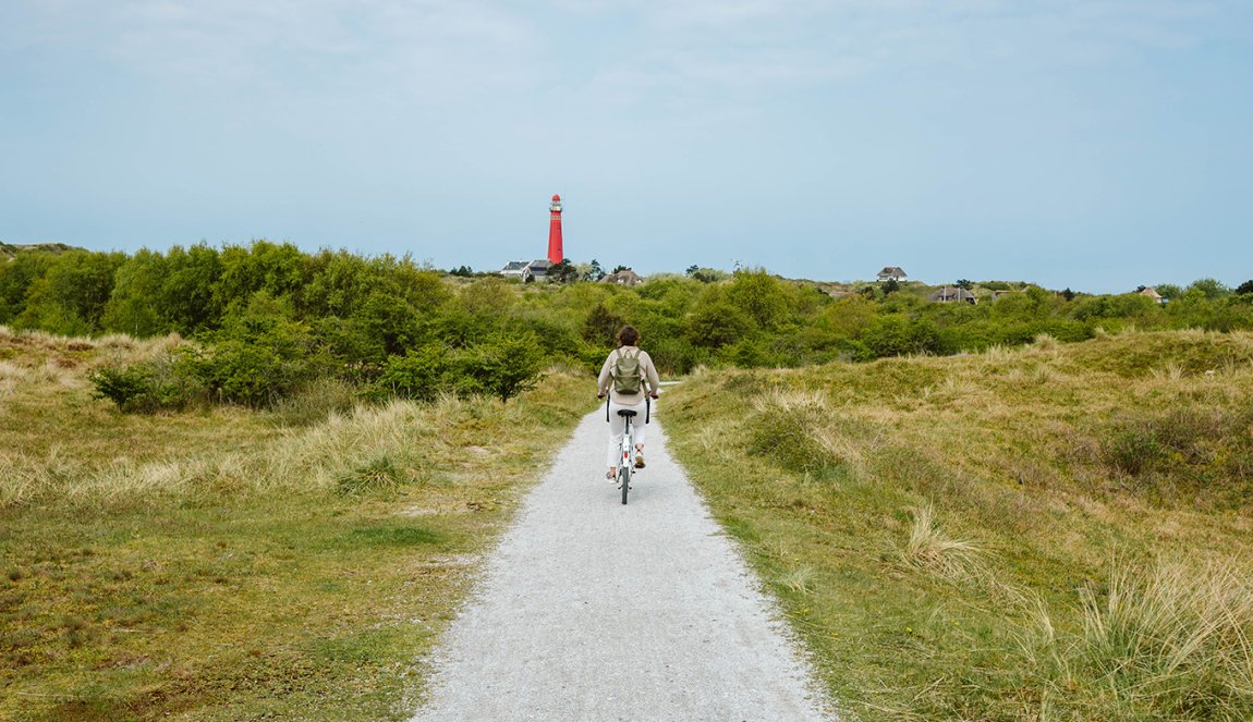 Cyclist on Schiermonnikoog with the lighthouse in view