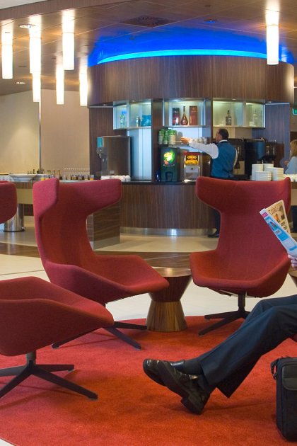 Business traveller reading a newspaper in the KLM Crown Lounge at Amsterdam Airport Schiphol