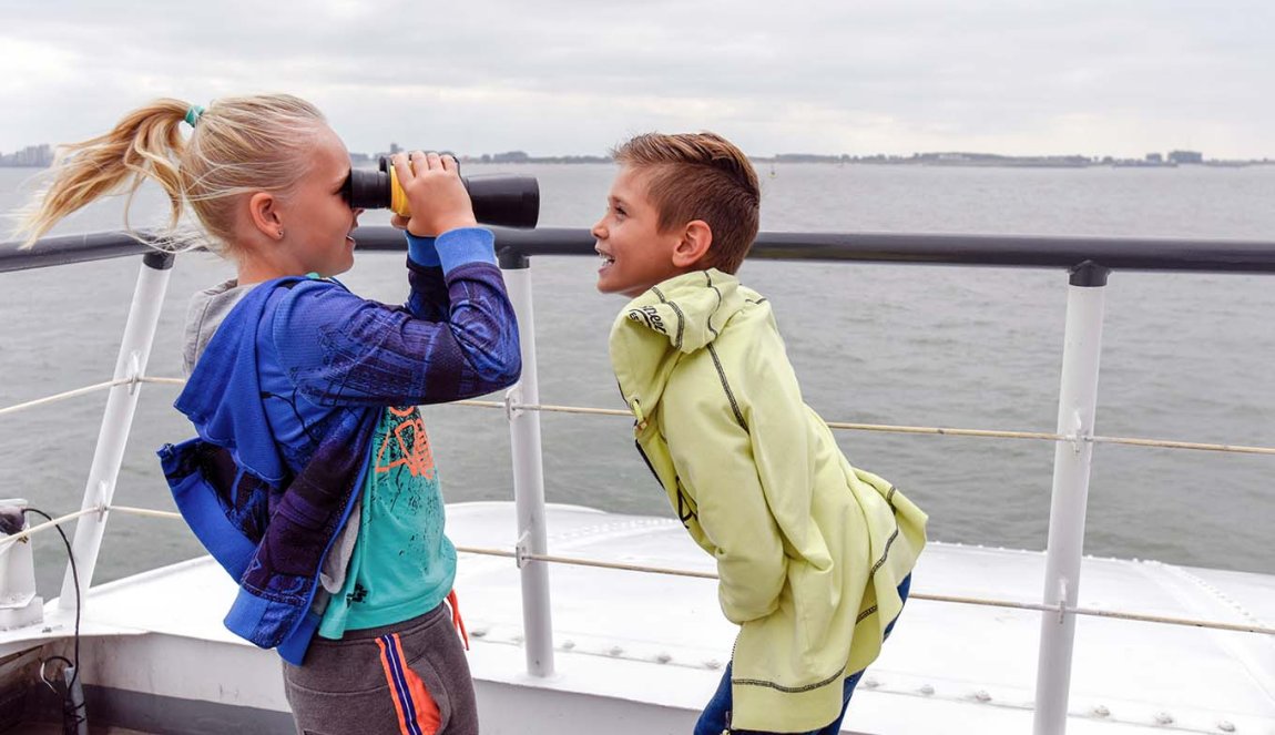 Children with binoculars in the wind on the deck of the Westerschelde Ferry