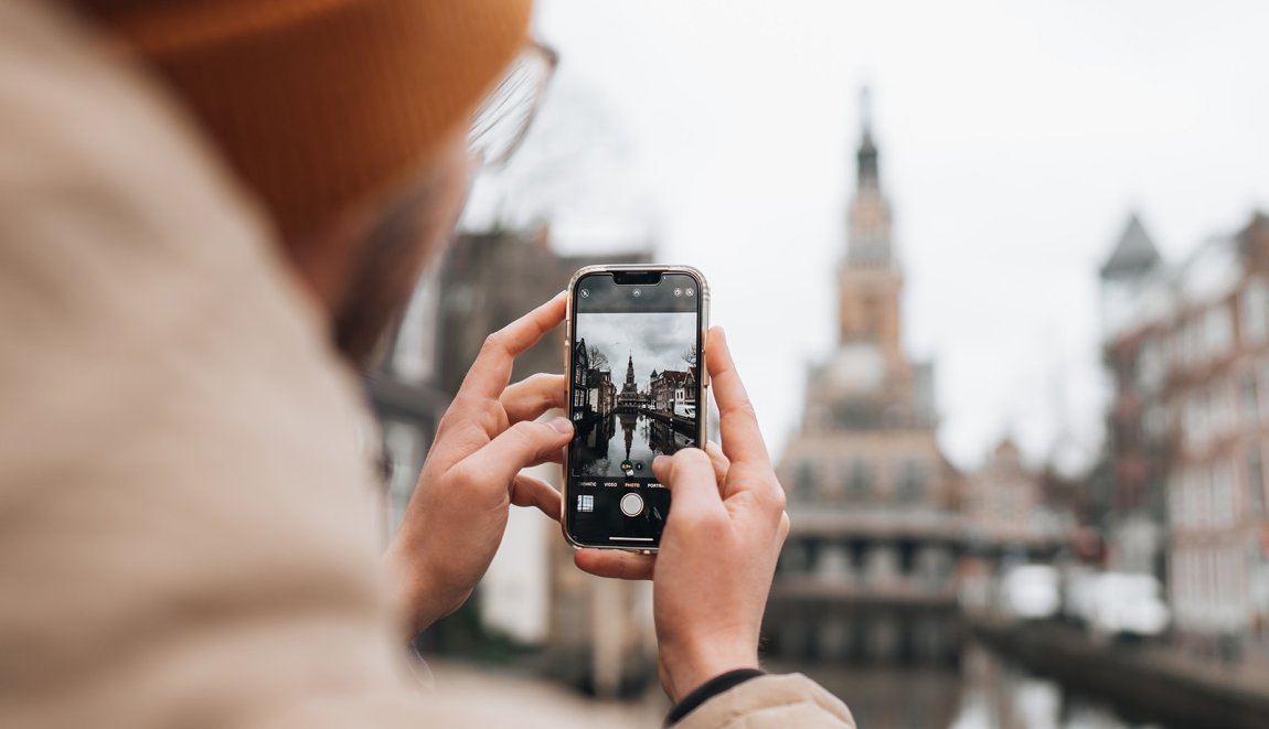 Person takes a photograph of the Waag in Alkmaar Person takes a photograph of the Waag in Alkmaar