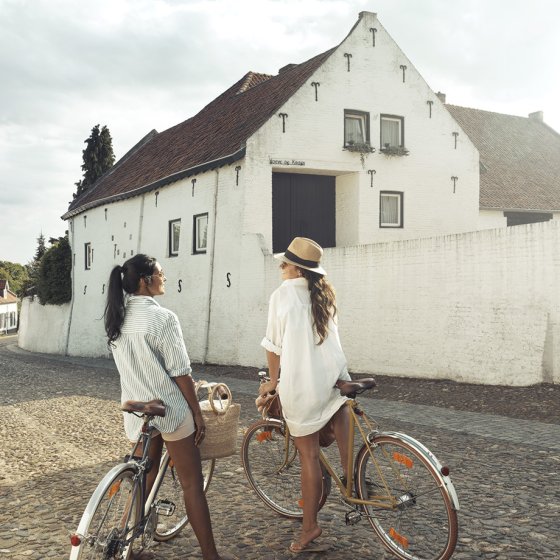 Thorn, South Limburg: two women with bicycles in a narrow street &copy; Hugo Thomassen via Maastricht Marketing