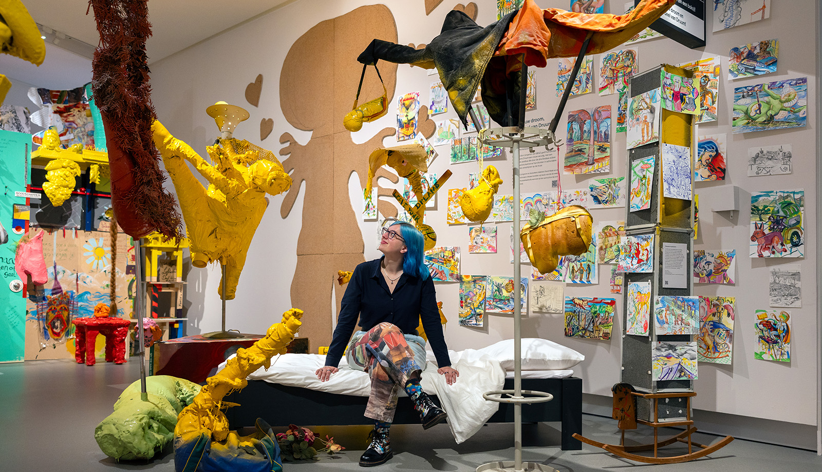 Visitor exploring colourful contemporary artworks by David Bade at Stedelijk Museum Breda