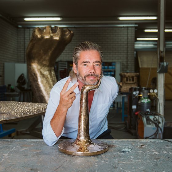 Portraitphoto Job Smeets with his head on bronze hand