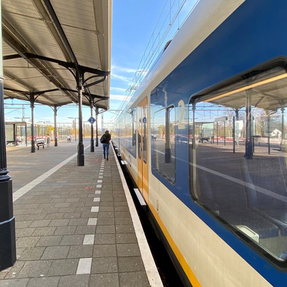 Someone walks to the train at NS station Geldermalsen