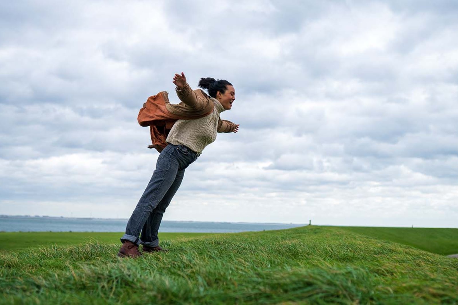 Woman hangs against strong headwinds in Zeeland