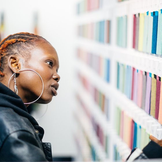 Lady looks at fabrics for sock knitting machine