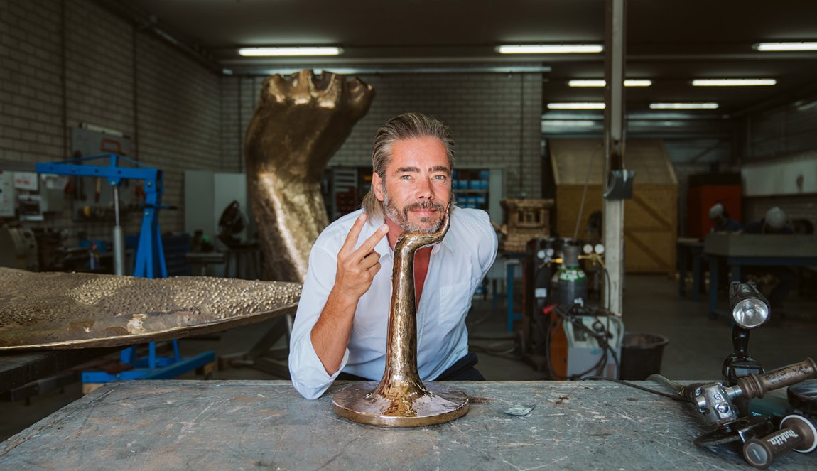 Portraitphoto Job Smeets with his head on bronze hand