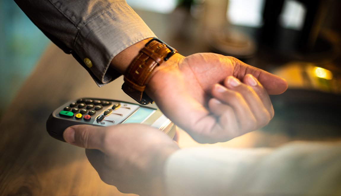 Hand with a smartwatch making payment transaction.