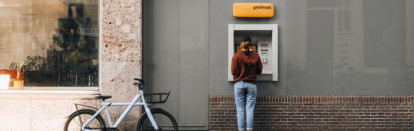 Lady parked her bike to withdraw money at Geldmaat (Dutch ATM) Lady parked her bike to withdraw money at Geldmaat (Dutch ATM)