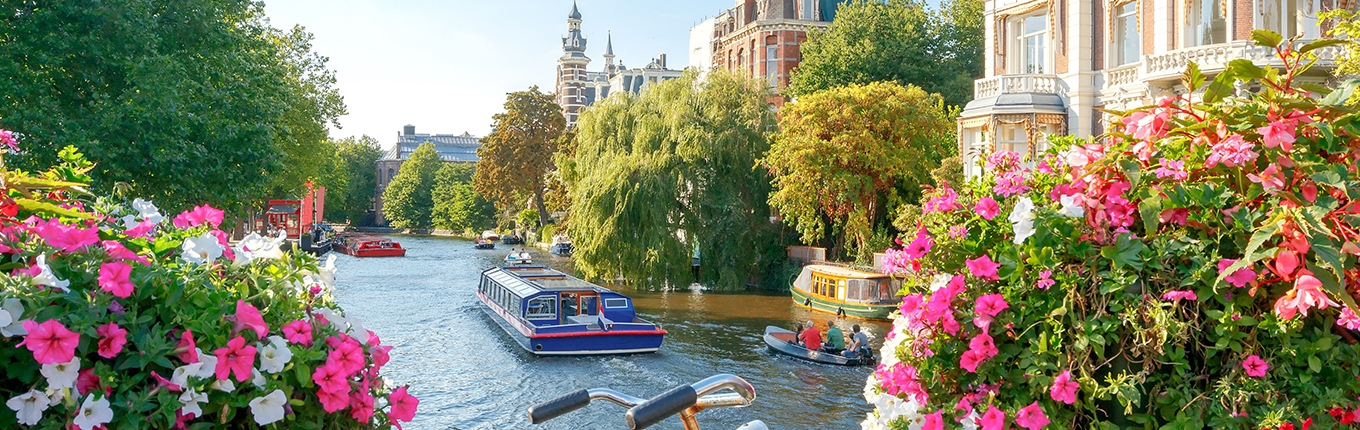 Amsterdam canals with boats view from a bridge with a bike Amsterdam canals with boats view from a bridge with a bike