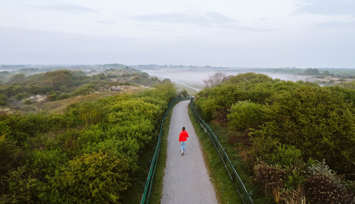 View of Schiermonnikoog with women in a red coat walking