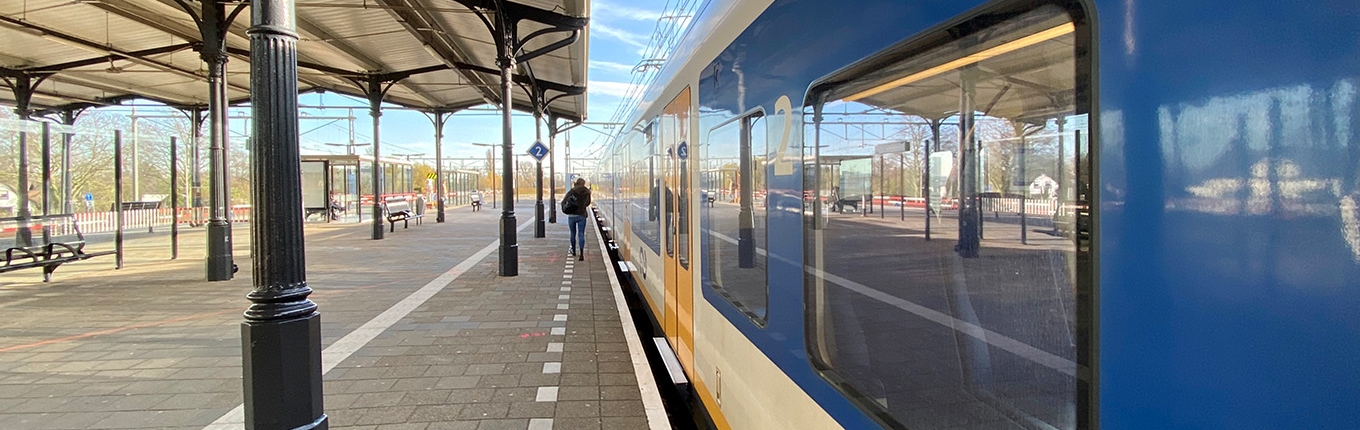 Someone walks to the train at NS station Geldermalsen Someone walks to the train at NS station Geldermalsen