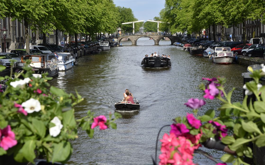 People in boats on Amsterdam canal People in boats on Amsterdam canal