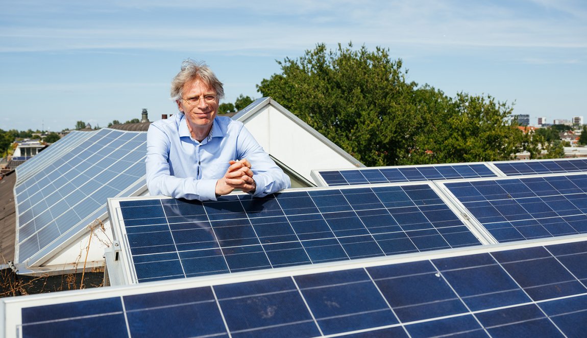 Portrait Robin Berg We Drive Solar with solar panels on the rooftop