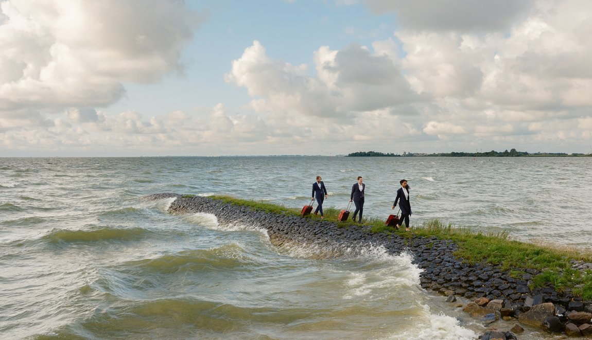 Three businesspeople on a pier in the Frisian countryside Three businesspeople on a pier in the Frisian countryside