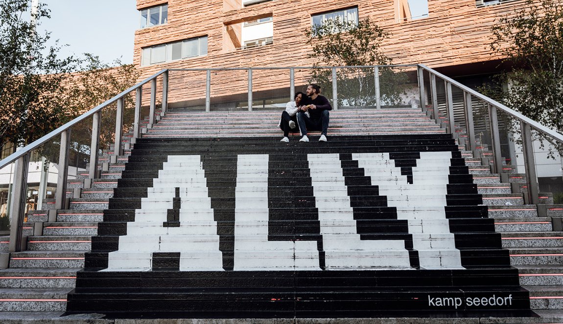 Couple sits on stairs with ALLY text