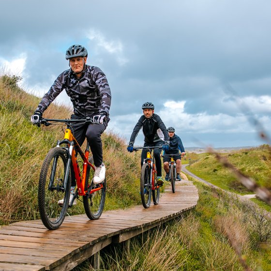 Through the dunes on a boardwalk on mountain bikes
