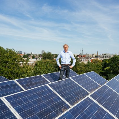 Portrait Robin Berg We Drive Solar standing on the roof with solar panels