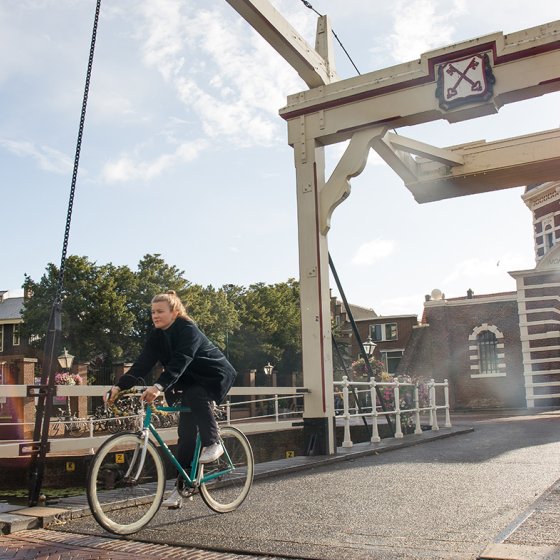 Lady cycling across the bridge Morspoort Leiden