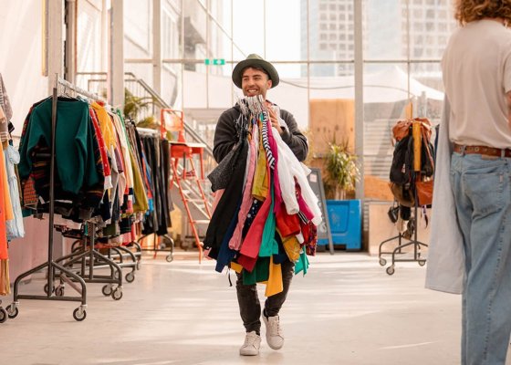 Sustainable shopping per kilo employee with handful of clothes at Kilo Kilo Vintage