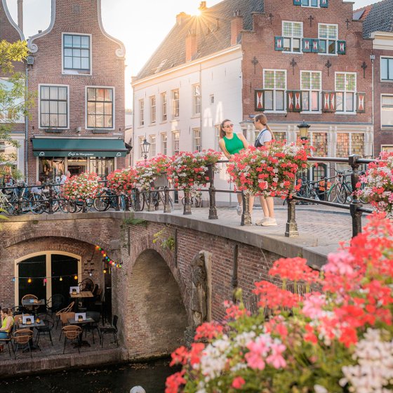 Chatting on the square in a summery atmosphere in Utrecht, with the bridge and water