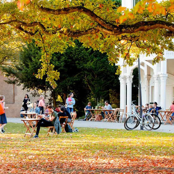 Visitors enjoying the terrace at Parqiet in Rotterdam, surrounded by autumn trees.