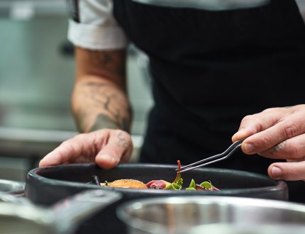 Hands of the chef garnishing food in a restaurant kitchen Hands of the chef garnishing food in a restaurant kitchen