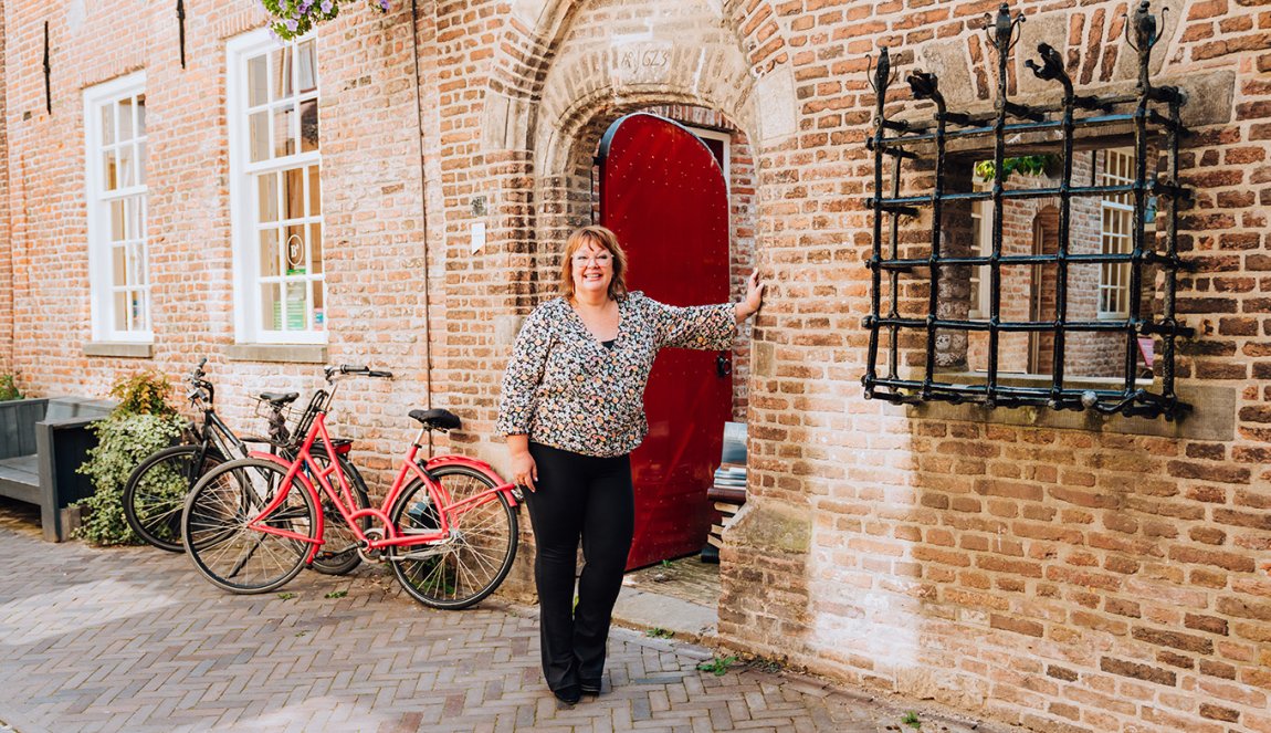 Judith Elders against building with red door