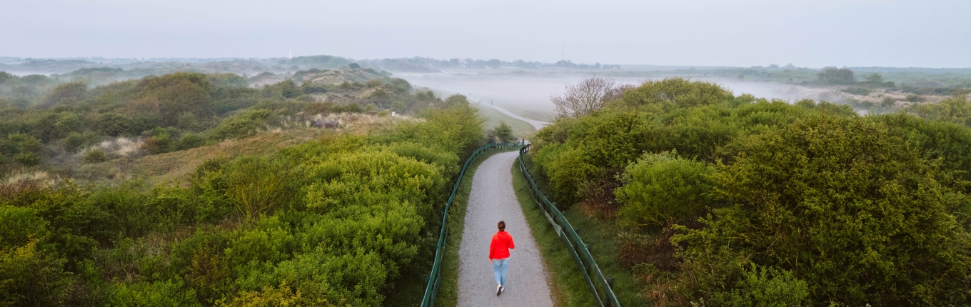 View of Schiermonnikoog with women in a red coat walking View of Schiermonnikoog with women in a red coat walking