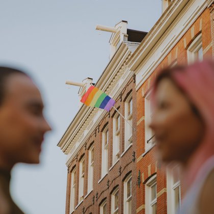 Rainbow flag on a historic city building, representing LGBTQ+ visibility and Pride in the Netherlands