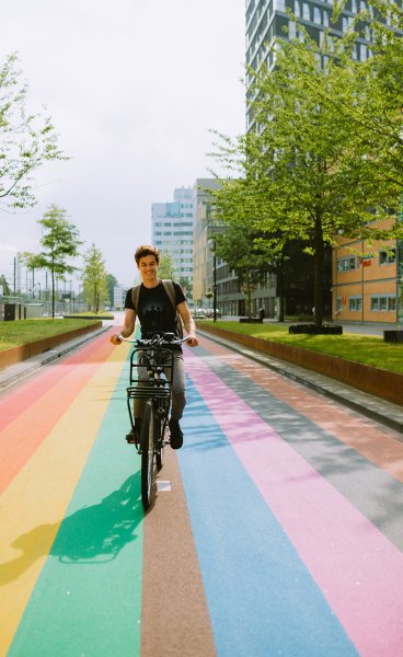 Man bikes across rainbow bike path in Utrecht