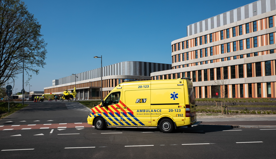 Yellow ambulance in front of hospital Yellow ambulance in front of hospital