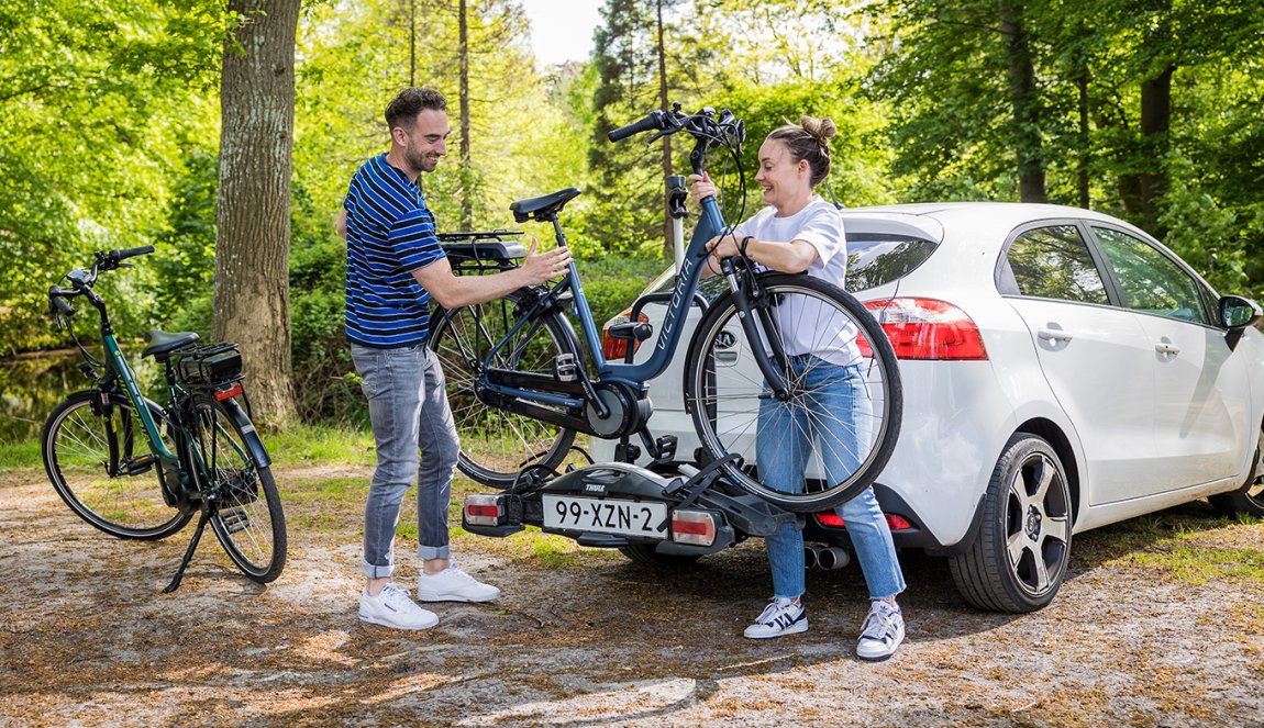 Young couple puts bikes on car's bike rack 