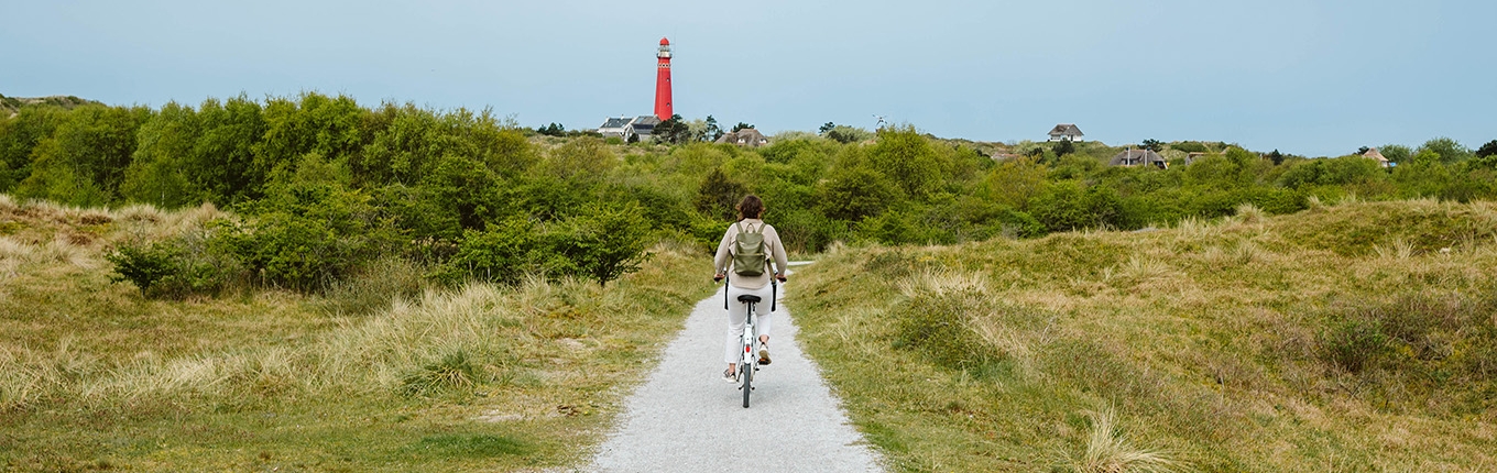 Cyclist on Schiermonnikoog with the lighthouse in view