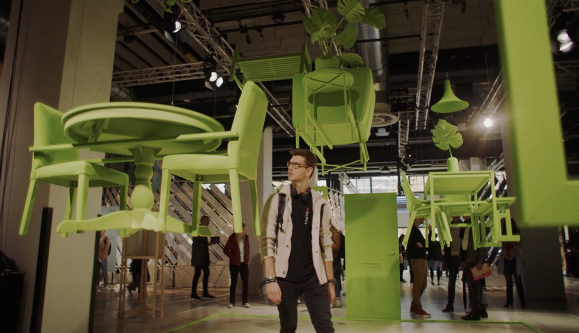 Visitor among green flying furniture during Dutch Design Week