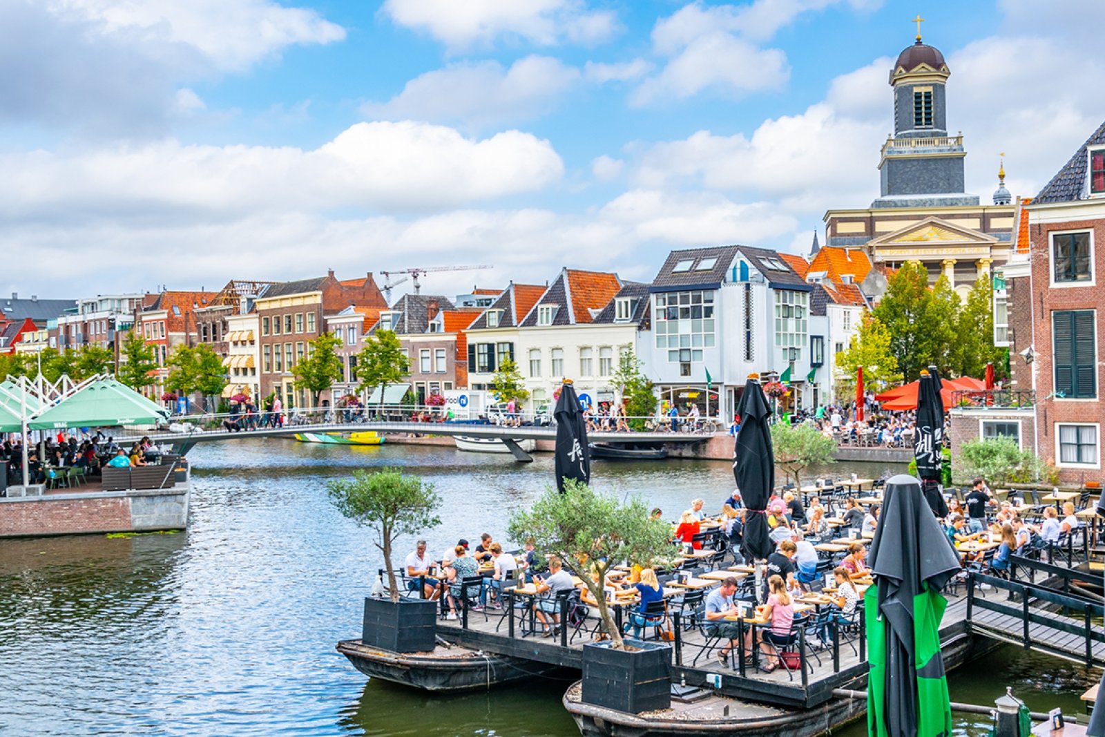 View of Hartebrugkerk from canal with terraces Leiden trabantos