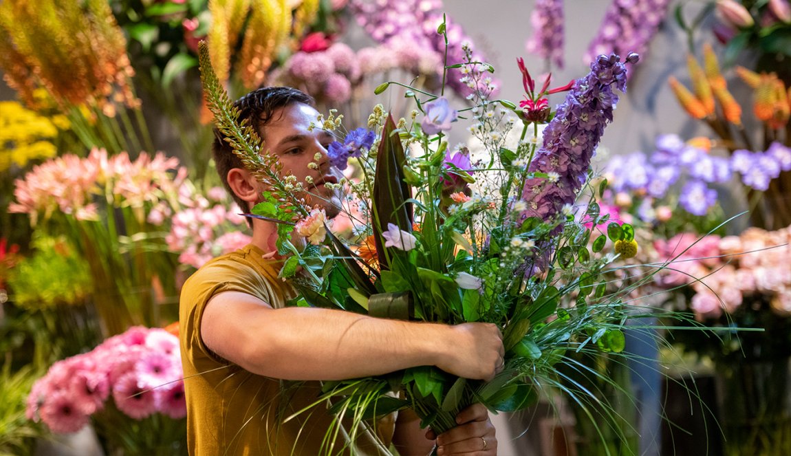 Arranging flowers. Big bunch of flowers in arms.