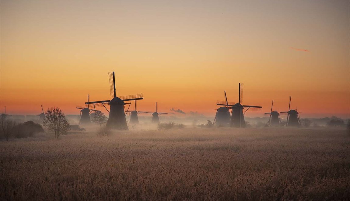 The windmills of Kinderdijk in the light of morning glory with a sunrise. The windmills of Kinderdijk in the light of morning glory with a sunrise.