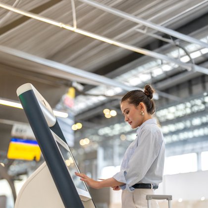 A female traveler checks in using digital check-in at the airport