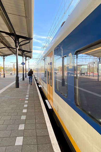Someone walks to the train at NS station Geldermalsen