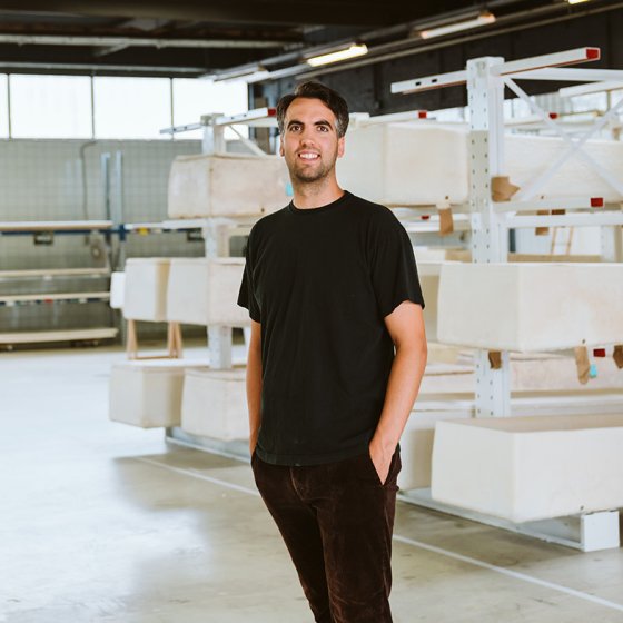 Studio Hendrikx Bob in front of a rack of environmentally friendly coffins 