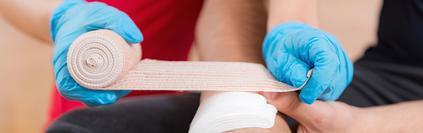 First aid training: blue gloves hand bandaging First aid training: blue gloves hand bandaging