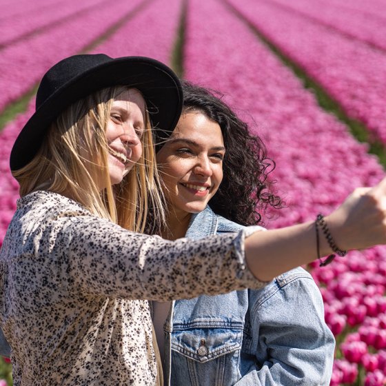 Ladies take selfie next to tulip field
