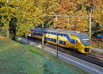 NS train travelling through an autumn landscape in the Netherlands