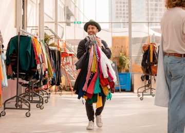 Sustainable shopping per kilo employee with handful of clothes at Kilo Kilo Vintage