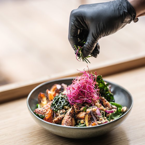 Chef garnishes colorful salad, fresh and beautifully presented