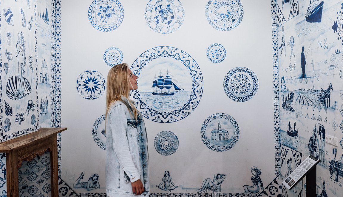 Zuiderzeemuseum Enkhuizen lady admires blue white wall Zuiderzeemuseum Enkhuizen lady admires blue white wall