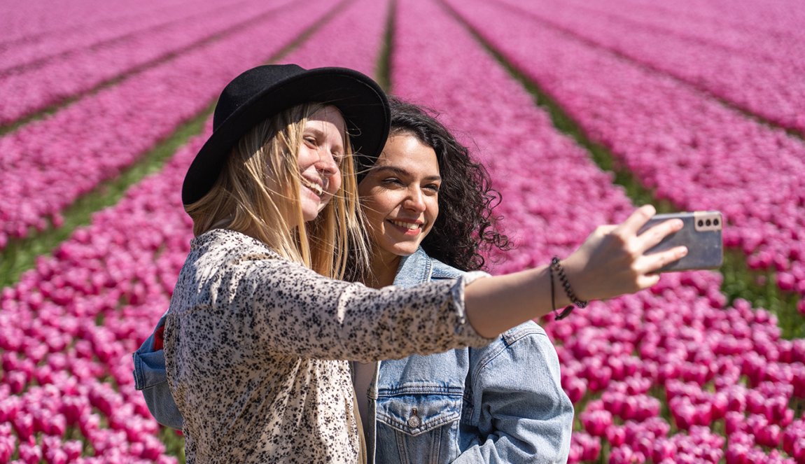 Ladies take selfie next to tulip field