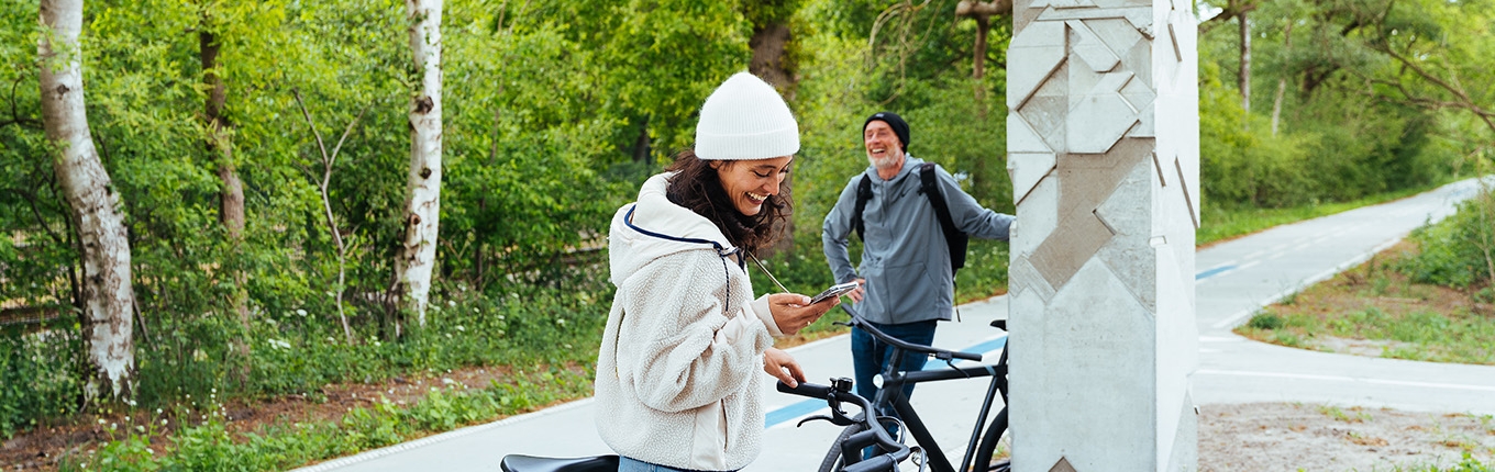 Cyclist checks bike app on phone Cyclist checks bike app on phone